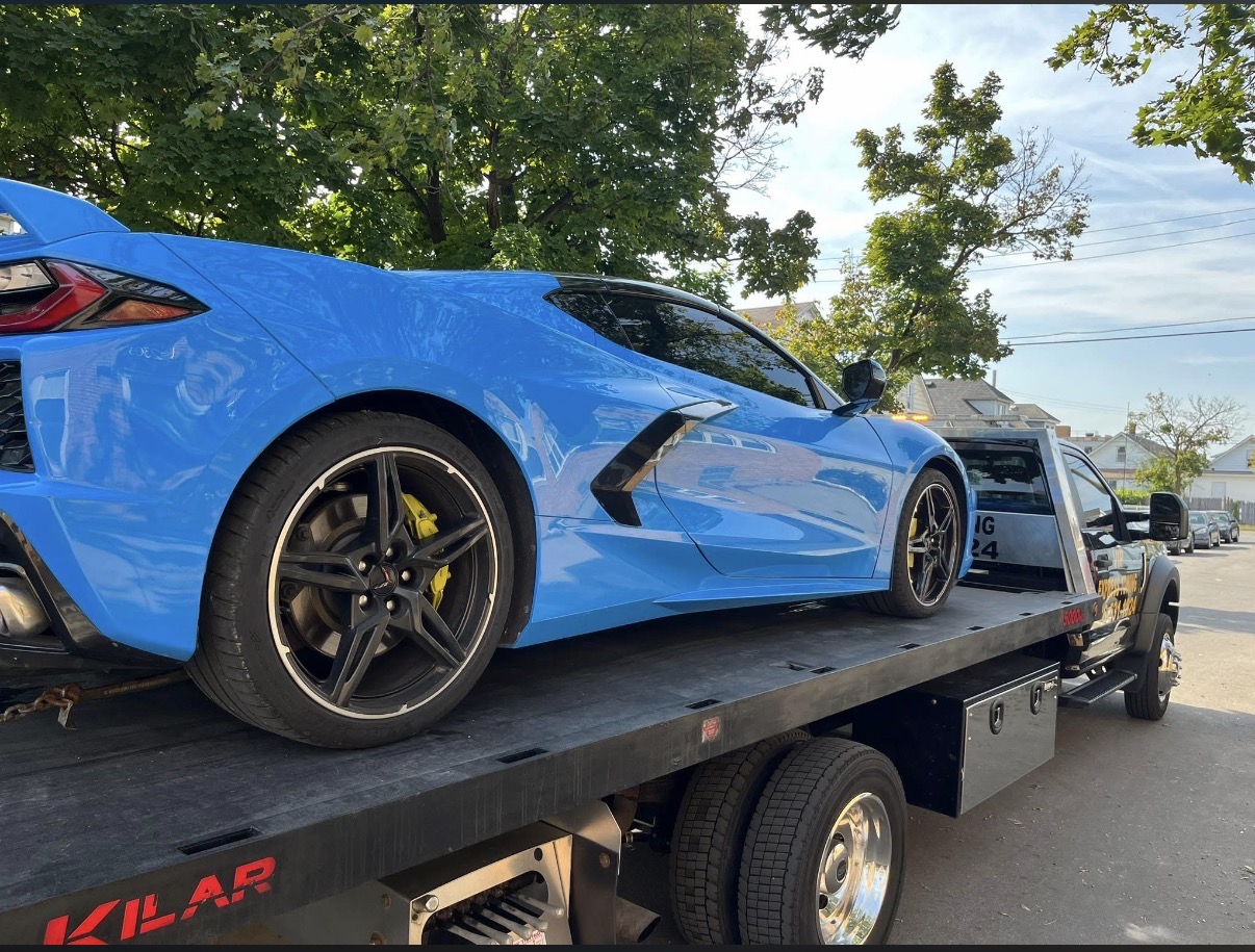 Blue sports car secured on a VIP Express Towing flatbed